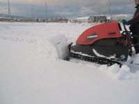 草刈りハンマーナイフモアが専用ブレードアタッチメントで除雪機として使用